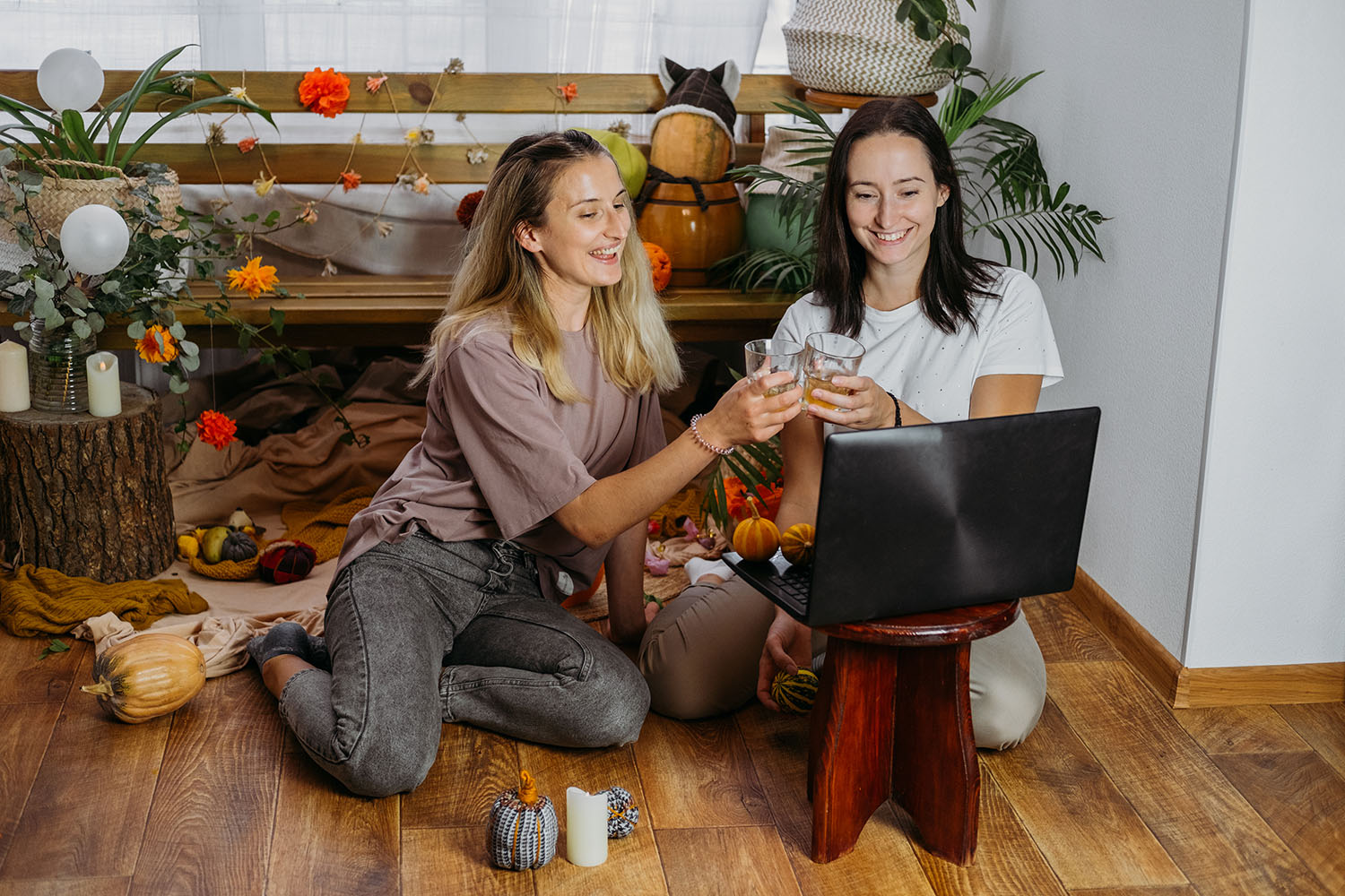 Two young women with their apple cider on a virtual meeting