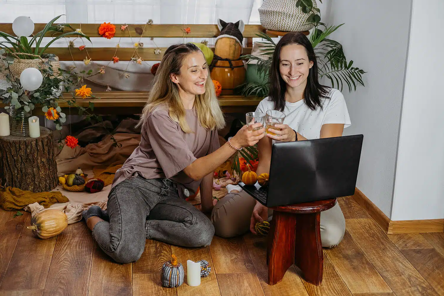 Two young women with their apple cider on a virtual meeting